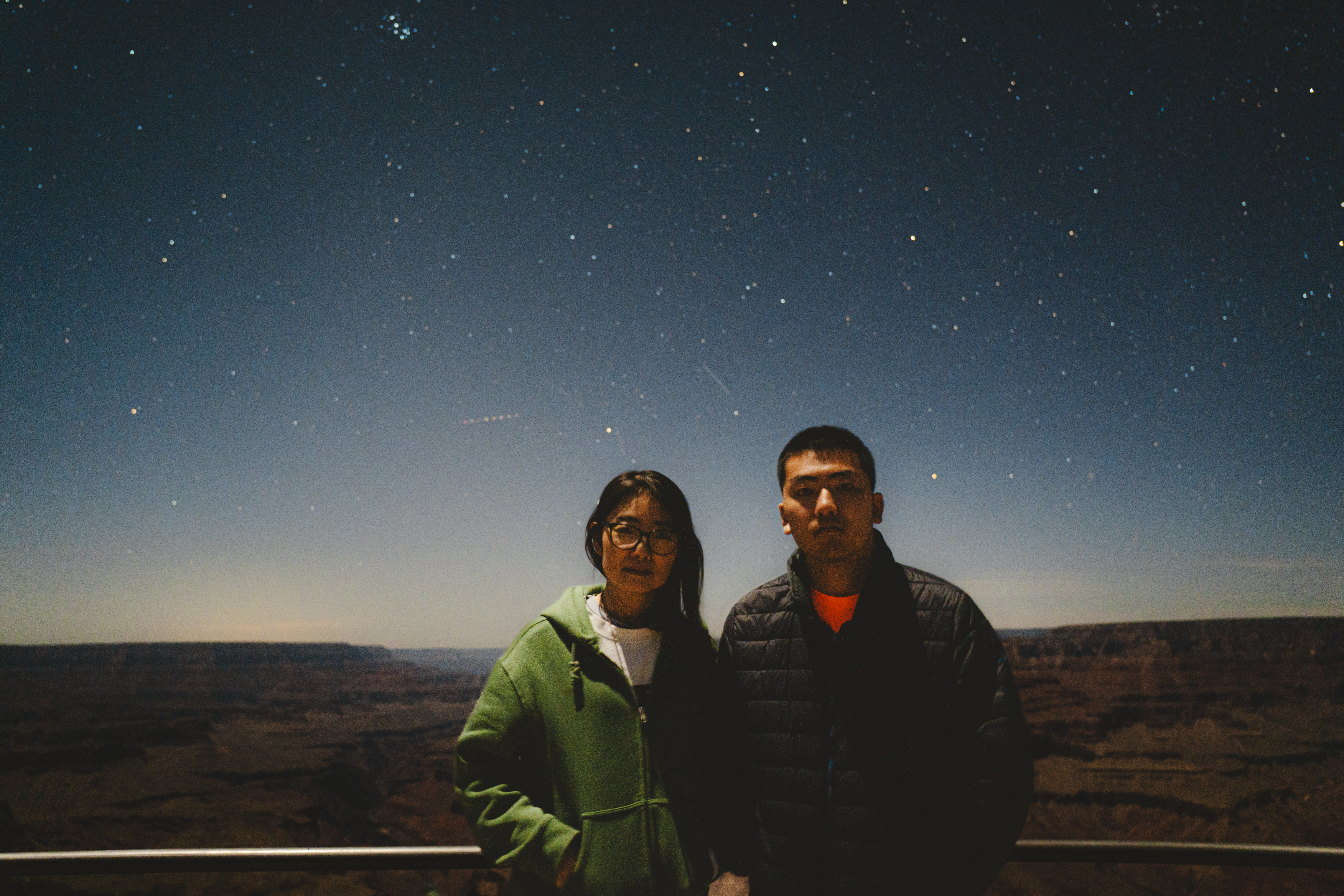 Gabriel and his mom beneath a star-filled night sky at the Grand Canyon.